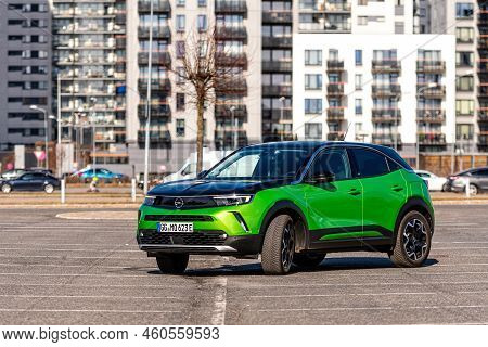 Riga, Latvia - 26 March, 2021: Green Electric Vehicle Opel Mokka-e In The Parking Lot On The Backgro