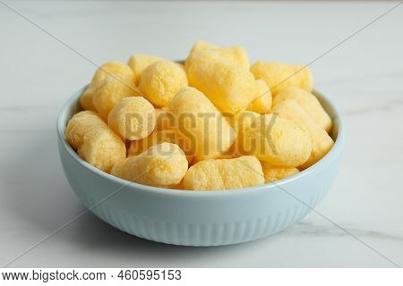 Bowl Of Delicious Crispy Corn Sticks On White Marble Table