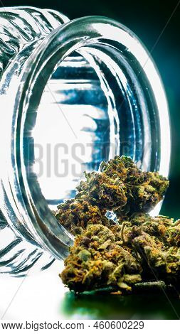 Marijuana Buds And Glass Cannabis Jar With Bright Light Shining Through.