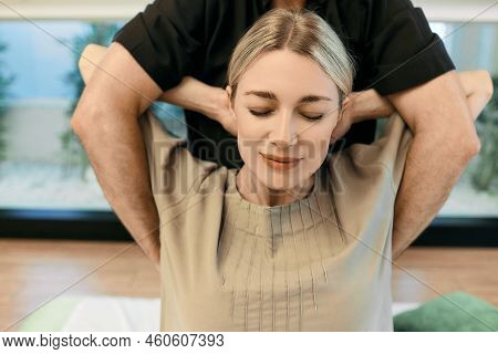 Therapeutic Massage Yumeiho. Massage Therapist Doing Recovery Exercises For Female Patient With Hand
