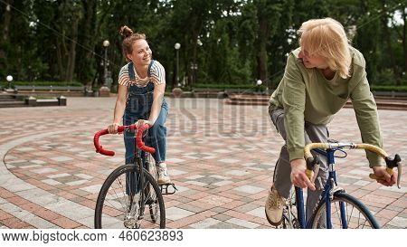 Young Smiling Caucasian Couple Riding Bicycles On City Square. Modern Urban Teenager Lifestyle. Ente