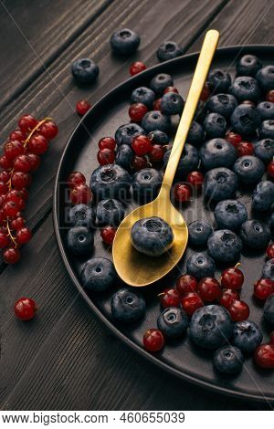 Fresh Blueberries And Red Currant Close-up Arrangement In Gold Spoon And Black Dish Selective Focus 