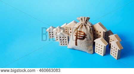 Philippine Peso Money Bag Surrounded By Houses. Buying Apartments. Mortgage Loan. Real Estate. Budge