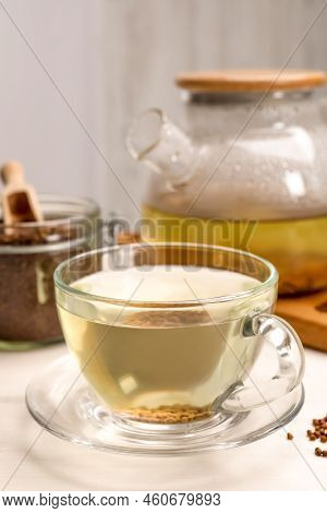 Buckwheat Tea In Glass Cup And Granules On White Wooden Table, Closeup
