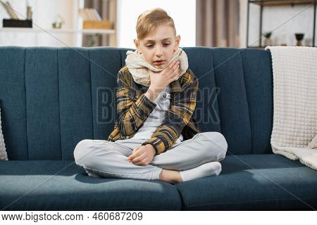Cold And Flu Season. Sick Teenage Boy With High Fever And Sore Throat And Feeling Bad, Sitting At Ho