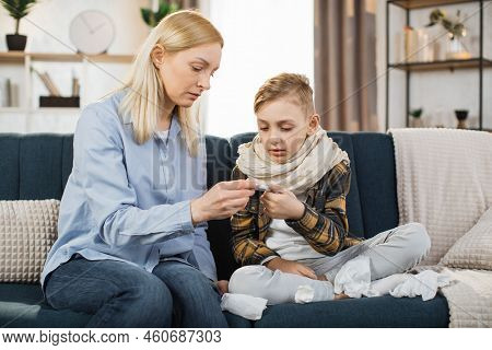Mature Blond Woman, Checking Her Sick Boy Temperature On Thermometer After Measuring. Sad Ill Child,