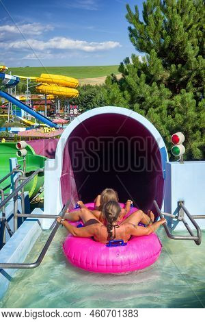 Liptovsky Mikulas, Slovakia - August 4, 2022: People Ready To Slide On Pink Inflatable In Water Slid