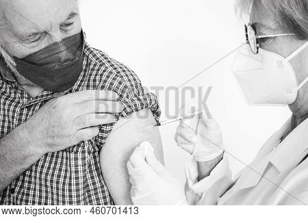 Doctor Giving Injection To Senior Caucasian Man, Old Retired Receiving Booster Of Covid 19 Vaccine, 