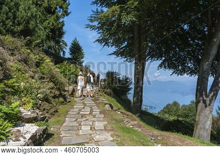 Tourists Hiking In Giardino Botanico Alpinia Park Near Stresa. Stresa Is A Town In Piedmont In North