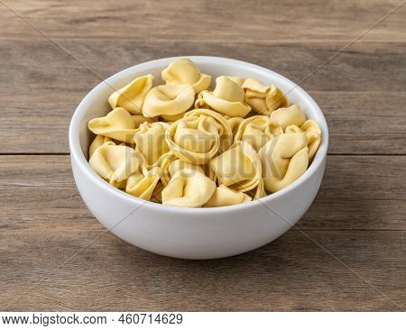 Uncooked Cappelletti Or Tortellini On A Bowl Over Wooden Table.