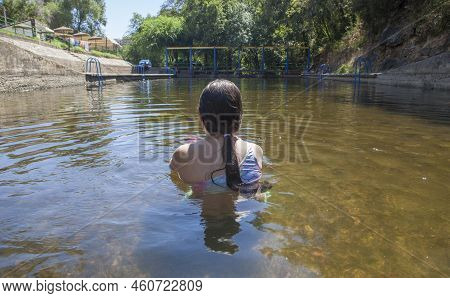 Child Girl Enjoying Vadillo Natural Swimming Pool, Water Spot In The Heart Of La Vera County. Losar 