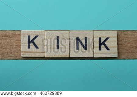 Word Kink Made From Wooden Gray Letters Lies On A Green Background
