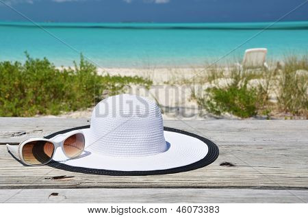 Čepice a brýle na pláži Exuma, Bahamy