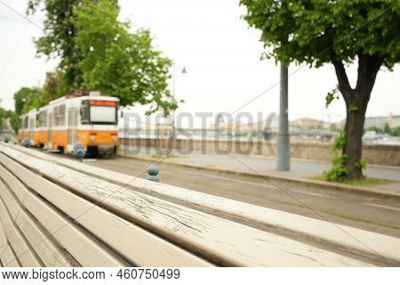 Yellow Tram Approaching On Tracks Next To River
