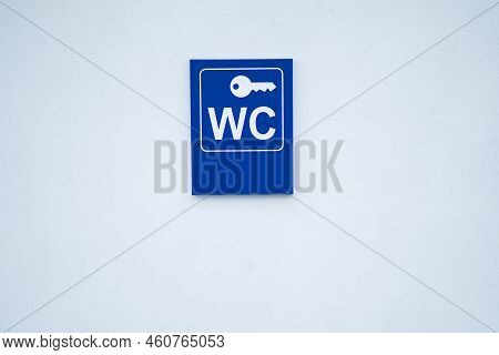 Wc Sign On The Wall With Key Sign Above It