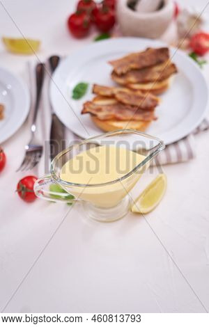 Classic Hollandaise Sauce Of Butter And Egg Yolks Served In A Gravy Boat