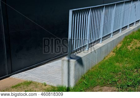 Galvanized Metal Railings At A Gray Sheet Metal Industrial Hall. Concrete Gray Railing At The Ramp. 