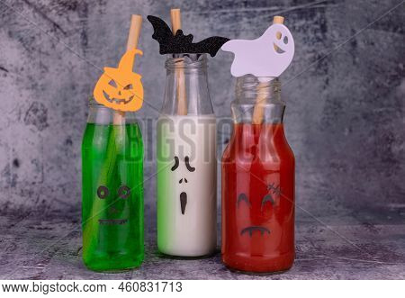 Drink Idea For Halloween Party. Drinks In Bottles With Monster Faces. Jack-o-lantern Face On Glass.
