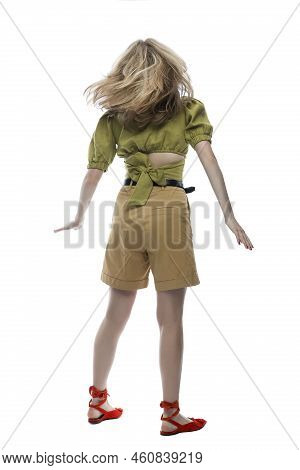 A Teenage Girl In Beige Shorts, A Green Blouse And Red Shoes Is Spinning With Her Hair Flowing. Acti