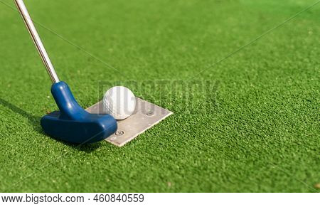 A Golf Club And A Ball During A Mini Golf Game