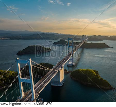 Overhead View Of Towers And Roadway On Long Suspension Bridge Through Small Islands In Late Afternoo