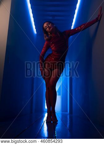 A Fashionable Photo Shoot With Tinted Blue, A Young Beautiful Model In A Scarlet Dress, In A Mysteri