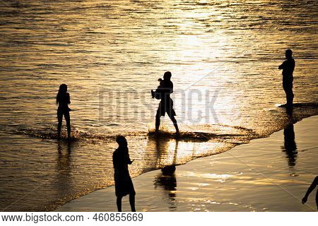 People Walking E Se Divertindo On The Sand Of Beach In The Late Afternoon.