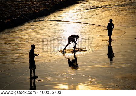 People Walking E Se Divertindo On The Sand Of Beach In The Late Afternoon.