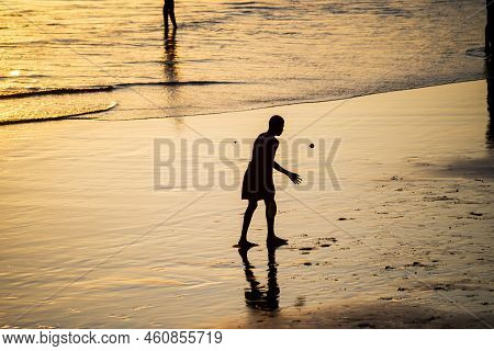 Young People Playing Frescoboll Against Sunset At Beach