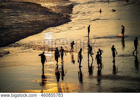 People Walking E Se Divertindo On The Sand Of Beach In The Late Afternoon.