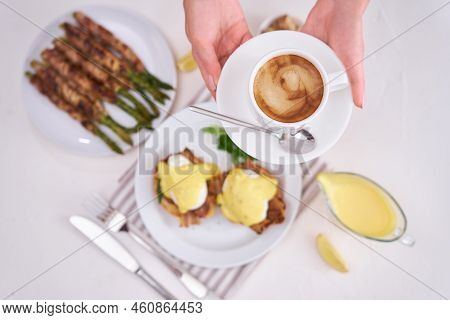 Tasty Eggs Benedict, Hollandaise Sauce And Aspargus Covered With Bacon