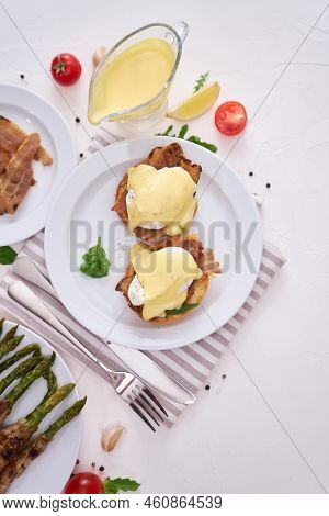 Tasty Eggs Benedict, Hollandaise Sauce And Aspargus Covered With Bacon