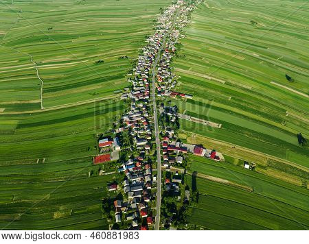 Aerial View Of Decorative Ornaments Of Diverse Green Fields And Houses Arranged In A Line Along The 