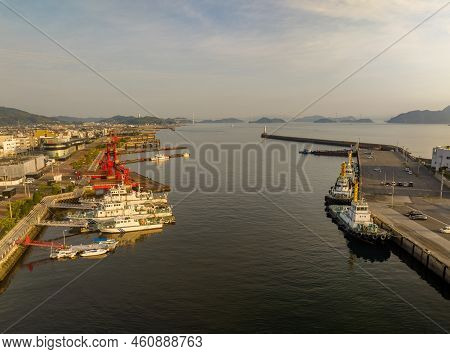 Row Of Tug Boats Docked Across From Small Fleet Of Patrol Boats In Harbor