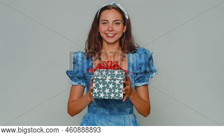Positive Smiling Lovely Pretty Young Woman Presenting Birthday Gift Box Stretches Out Hands, Offer W