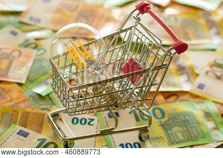 Rising Electricity Prices In Europe. Light Bulb In A Shopping Cart, Euro Bills.electricity Cost. Ele