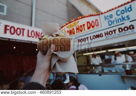 St. Paul, Minnesota - September 3, 2022: Woman Holds Up A Half-eaten Footlong Hot Dog While At The A