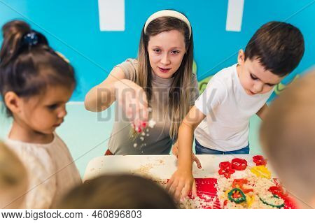 Creative Sensory Play With Moldable And Fluffy Kinetic Sand At Nursery School. Toddlers With Their T