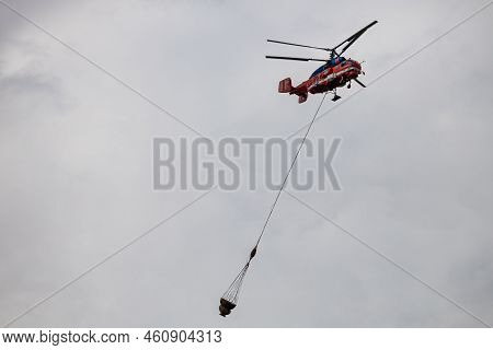 Moscow, Russia - July 21, 2022: Helicopter Carries Cargo In A Hanging Basket. High Quality Photo