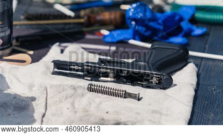 Handgun Broken Down Into Parts With Exposed Barrel At Gunsmith Workshop. Gun Maintenance Gear. Close