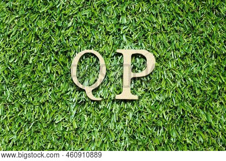 Wood Alphabet Letter In Word Qp (abbreviation Of Quality Procedure) On Green Grass Background