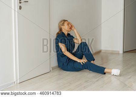 Tired Nurse Sits On Floor In The Lobby Of Medicine Clinic After A Hard Dutty