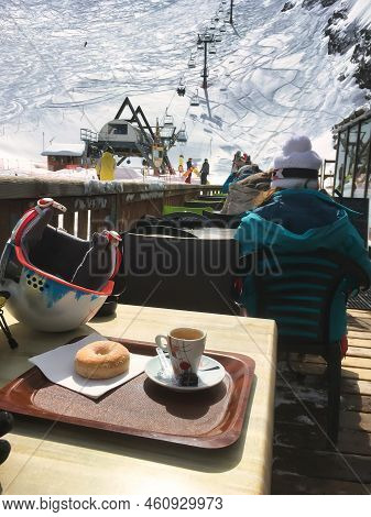 La Clusaz, France - March 05 2017 : Person Sitting On The Terrace Next To A Winter Sports Slope