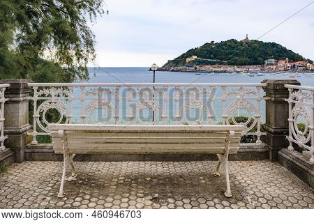 A Bench Overlooking Paseo De La Concha Promenade And La Concha Bay And Monte Urgull In San Sebastian