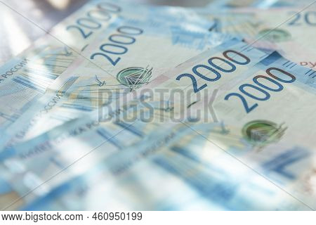 A Pile Of Russian Banknotes With A Face Value Of 2000 Rubles On The Table. Investments And Savings. 