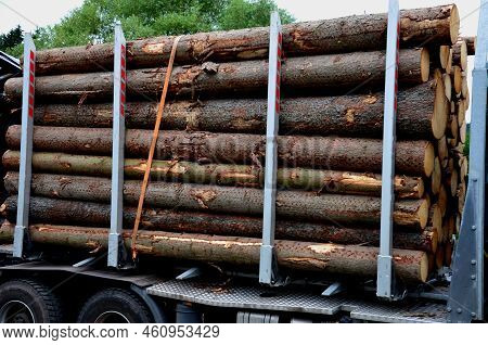 Loading Wood From The Forest. A Hydraulic Arm Feeds The Logs Onto The Truck\'s Lattice Semi-trailer.