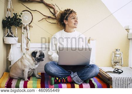 Modern Couple With Pretty Curly Woman And Funny Dog Pug Sitting On The Beanch At Home Working With A