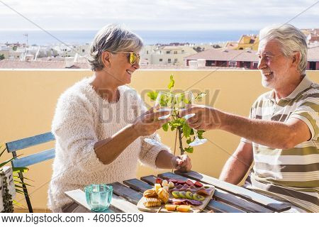 Nice Couple Of Retired Adult Stay Together On The Roofto Pterrace Eating And Drinking Some Food And 