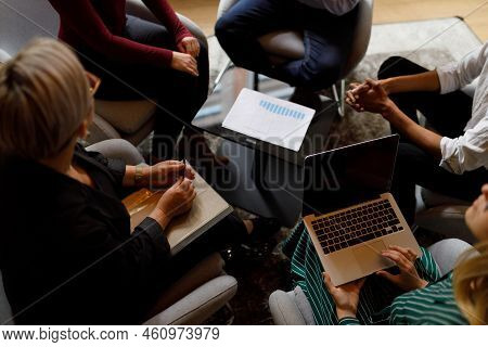 Anonymous Business People Gathered Around A Table For A Business Meeting While Using Technology And 
