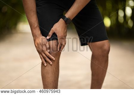 Cropped Of Portsman Exercising In Public Park, Touching Injured Ankle